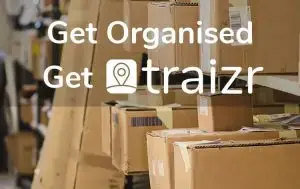 Stacks of cardboard boxes in a warehouse with overlaid text 'Get Organised Get Traizr' promoting Traizr internal mail tracking