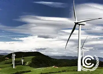 Wind turbines on grassy hills generating renewable energy for sustainable mail tracking